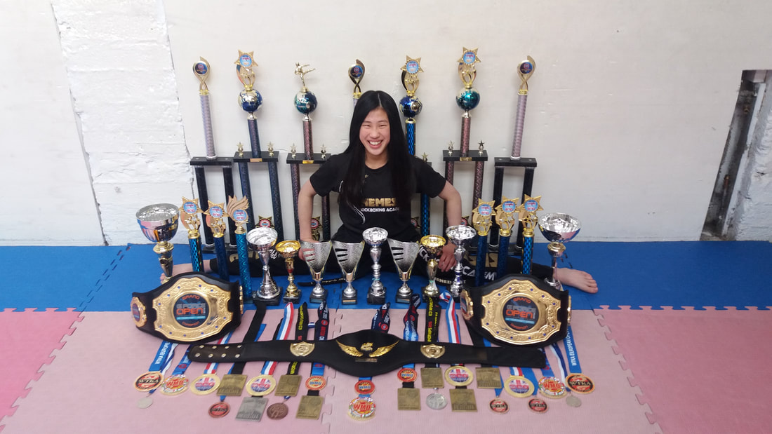 Amy Golder displaying her 2014 medals and trophy from the year competing.
